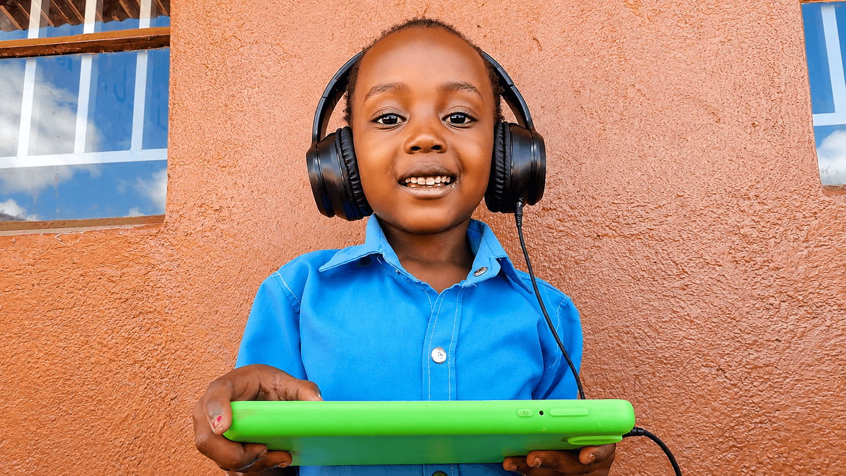 A young HFM student using a tablet and headphones