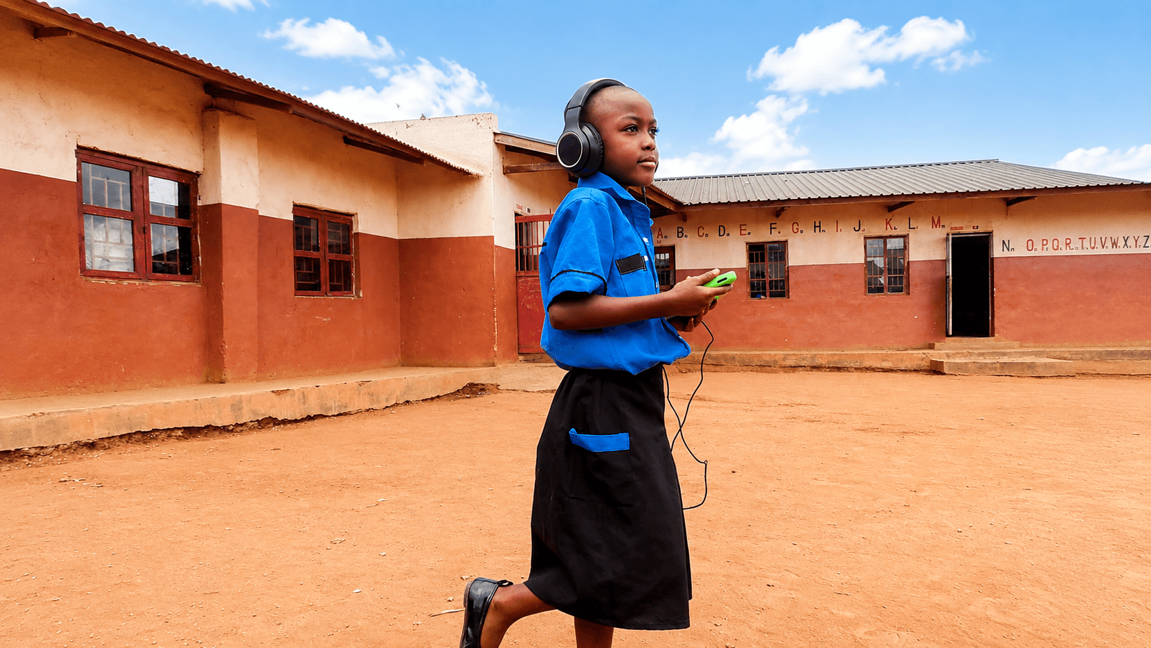 HFM student using headphones in the school courtyard